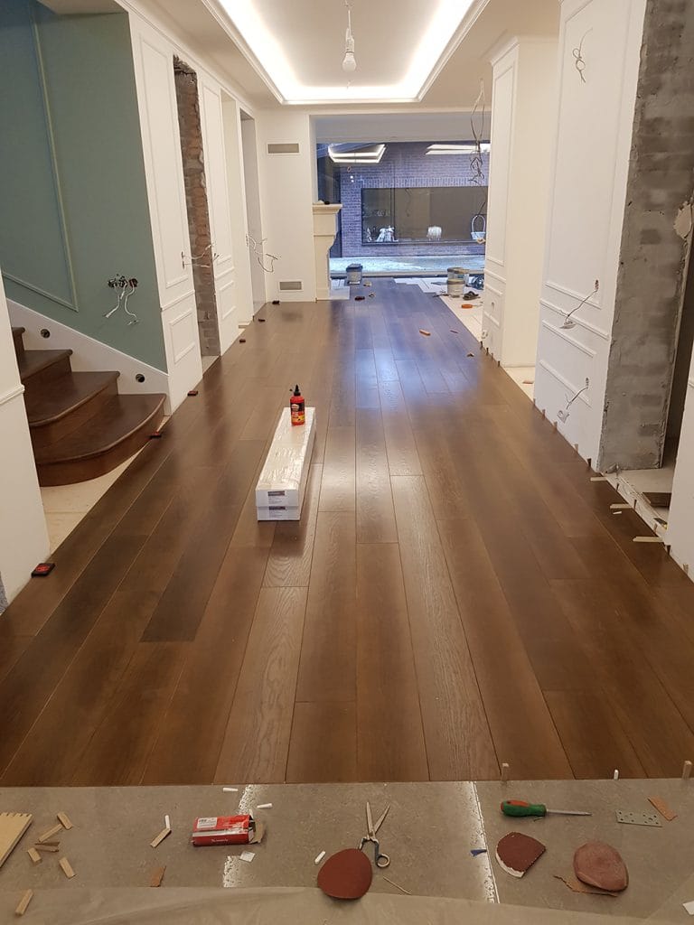 Пол из паркетной доски в частном доме на 140 м² во время укладки
